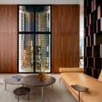 featured image of an elegant living room featuring a large custom-built glass wine cellar by the Wine Square and a stylish couch