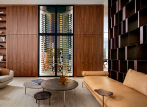 featured image of an elegant living room featuring a large custom-built glass wine cellar by the Wine Square and a stylish couch